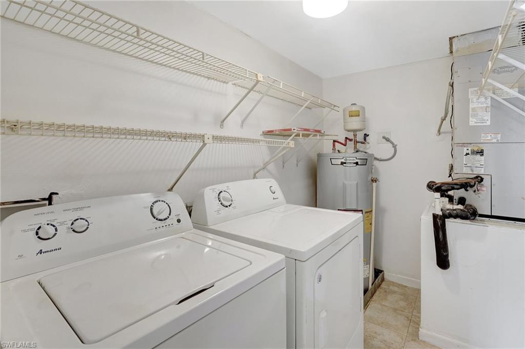 151 Cypress Way East, Unit D3 Naples, FL 34110 - Photo 10 of 46 Washroom with washing machine and clothes dryer, baseboards, laundry area, water heater, and heating unit