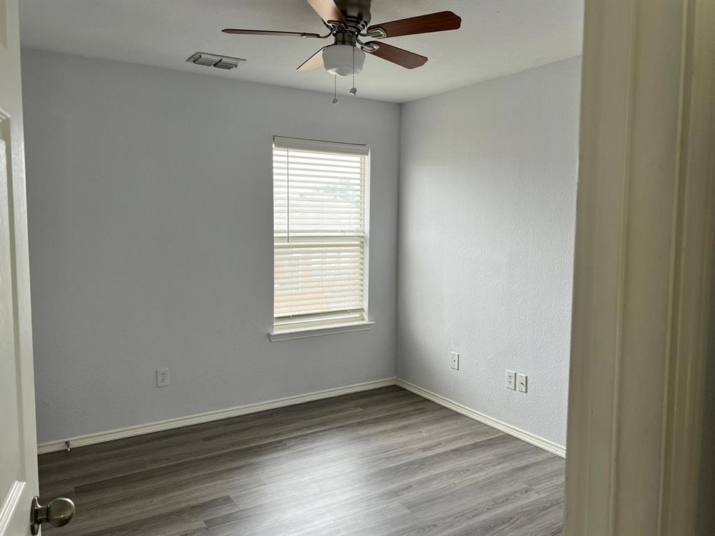 4312 Ridge Point Lane Plano, TX 75024 - Photo 3 of 16 an empty room with wooden floor fan and windows