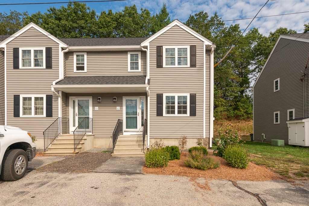 34 Lowell Road, Unit 12 Pepperell, MA 01463 - Photo 23 of 31 a front view of a house with a yard