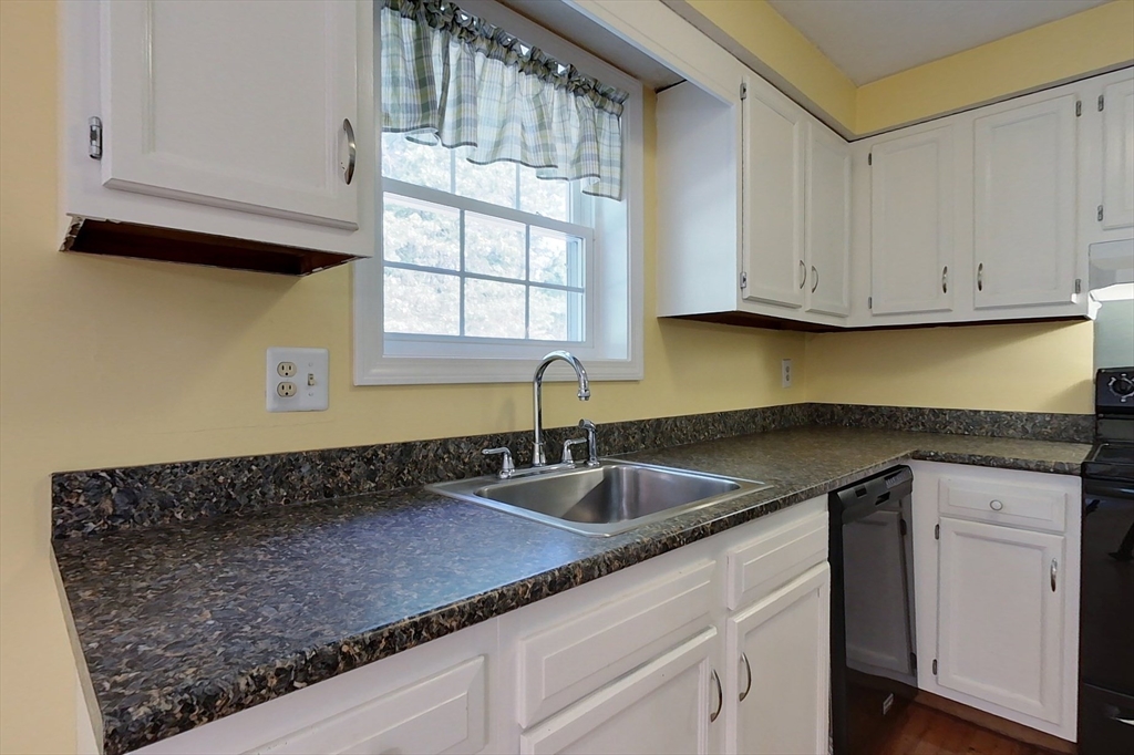 34 Lowell Road, Unit 12 Pepperell, MA 01463 - Photo 3 of 31 a kitchen with granite countertop a sink a stove and cabinets
