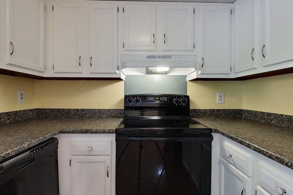 34 Lowell Road, Unit 12 Pepperell, MA 01463 - Photo 4 of 31 a kitchen with granite countertop white cabinets and a stove