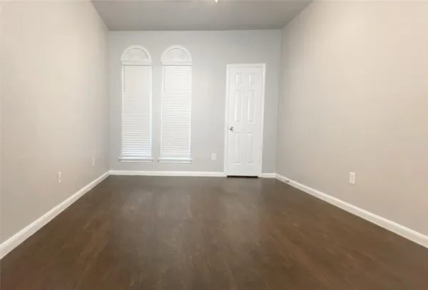 an empty room with wooden floor and window