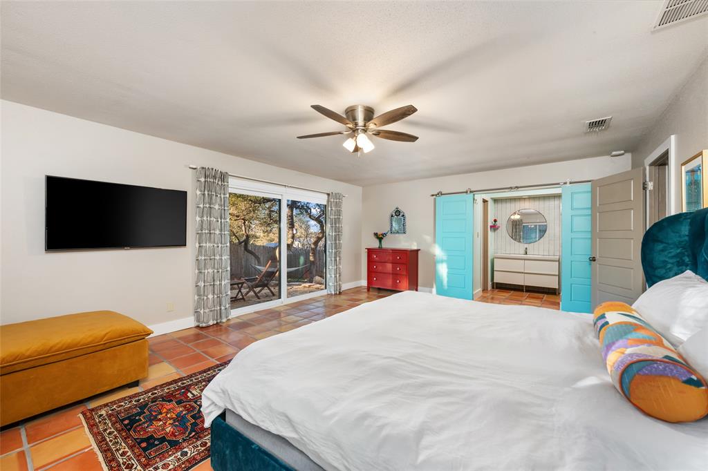 2210 Red Fox Road Austin, TX 78734 - Photo 26 of 40 Terracotta tiled bedroom with patio access offers a tranquil retreat.