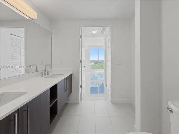 a spacious bathroom with a double vanity sink a and a mirror