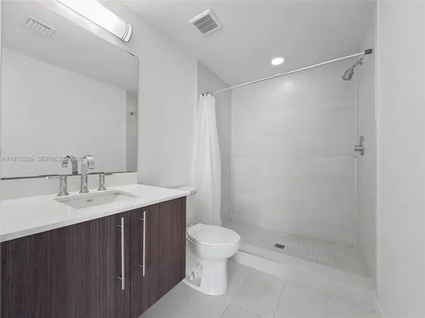 a bathroom with a granite countertop sink toilet a shower and a mirror