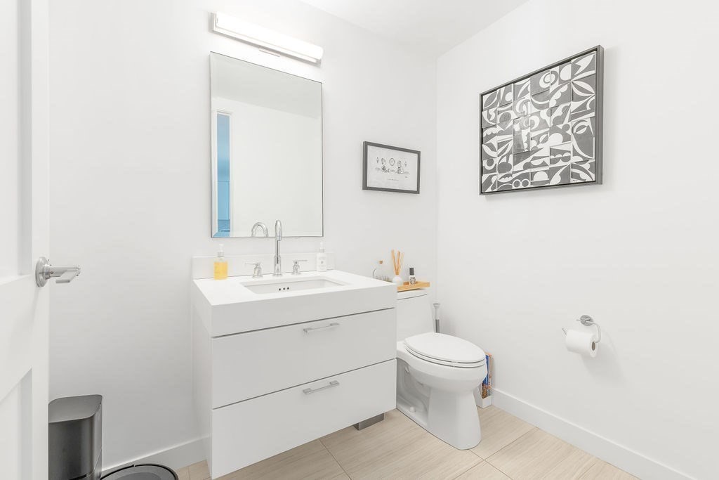 300 Pier 4 Blvd., Unit 8A Boston, MA 02210 - Photo 12 of 39 a bathroom with a toilet a sink and mirror