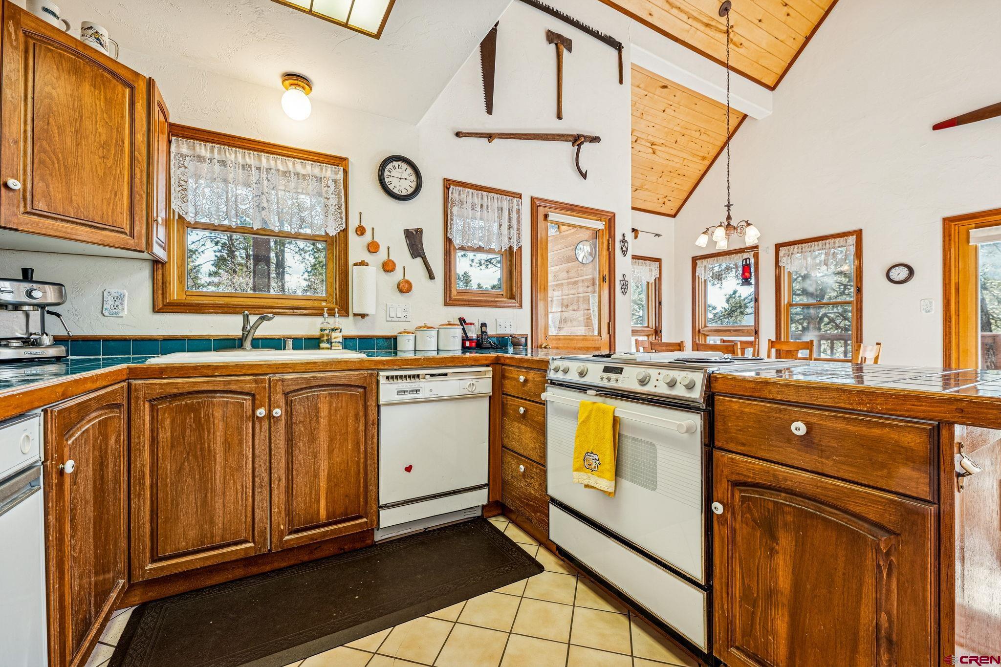 145 Cliffside Drive Durango, CO 81301 - Photo 19 of 43 a kitchen with stainless steel appliances granite countertop a stove a sink and dishwasher with wooden cabinets