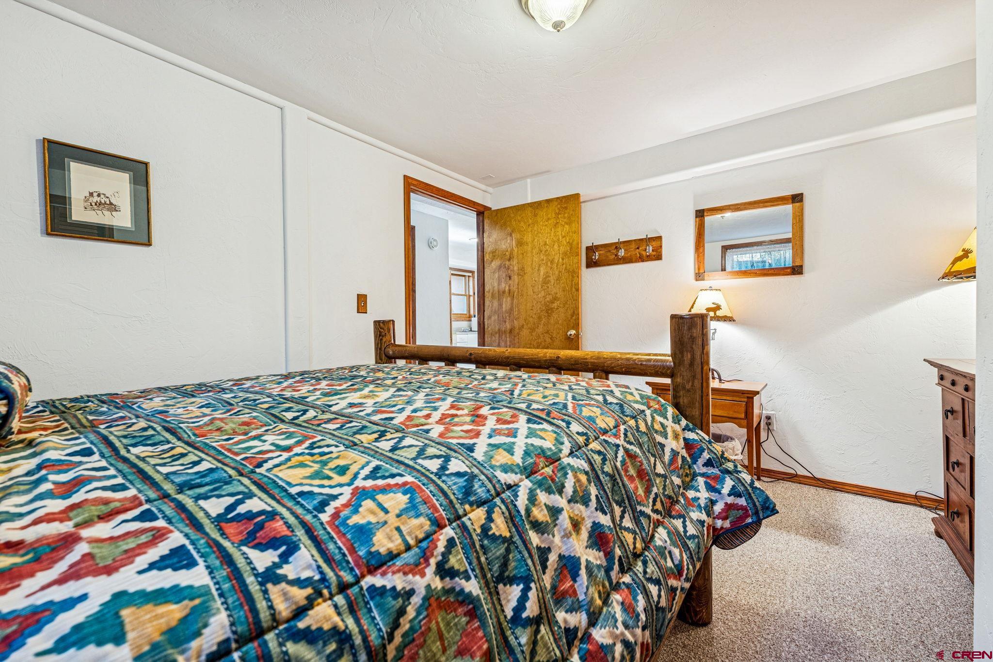 145 Cliffside Drive Durango, CO 81301 - Photo 40 of 43 a bedroom with a bed and a lamp on dresser