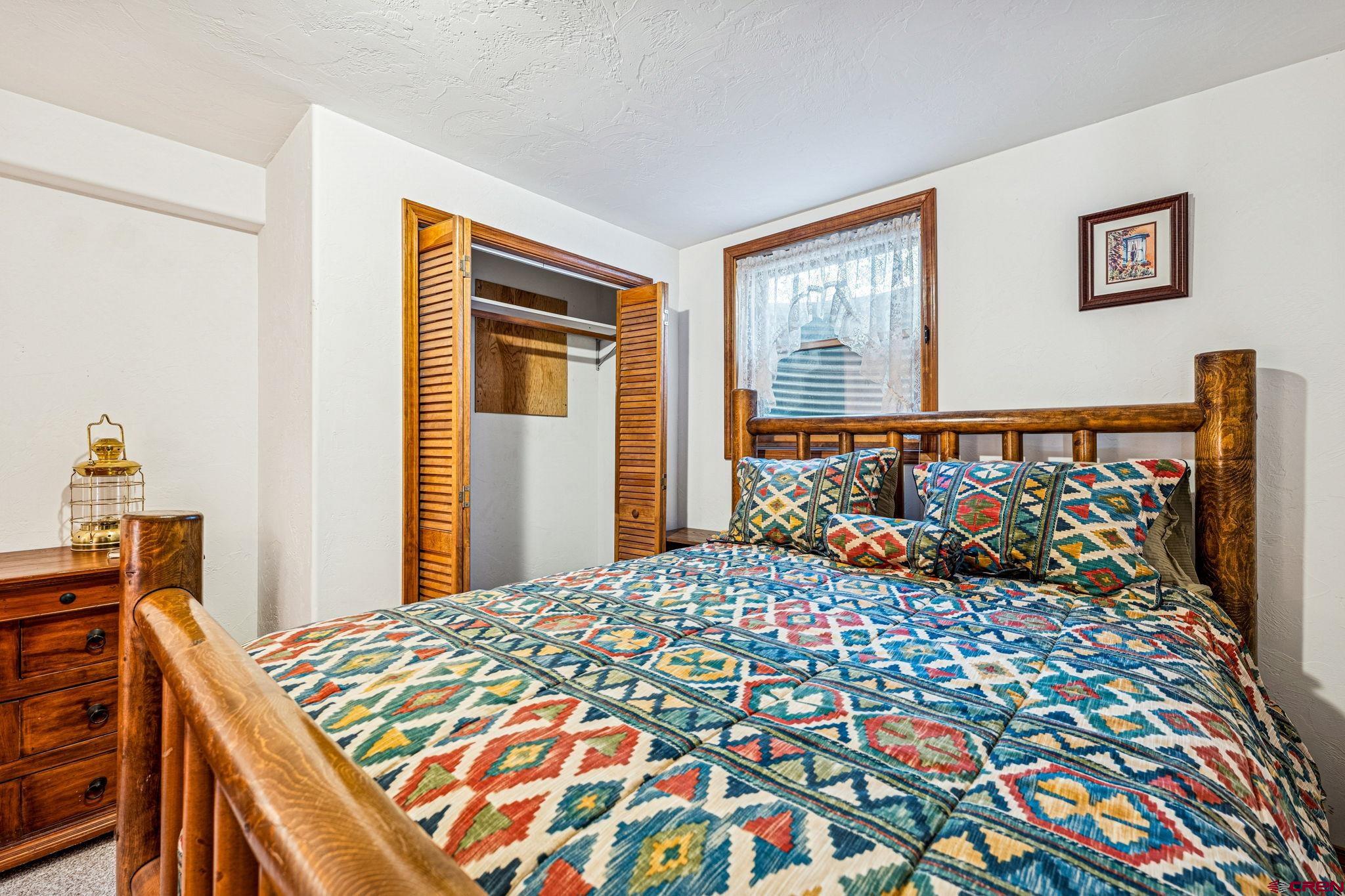 145 Cliffside Drive Durango, CO 81301 - Photo 41 of 43 a bedroom with a bed and wooden floor