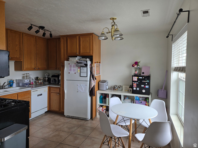 343 300 North, Unit 9 Provo, UT 84601 - Photo 6 of 10 Kitchen with wood finish cabinetry, white appliances, a chandelier, a textured ceiling, and light tile patterned flooring