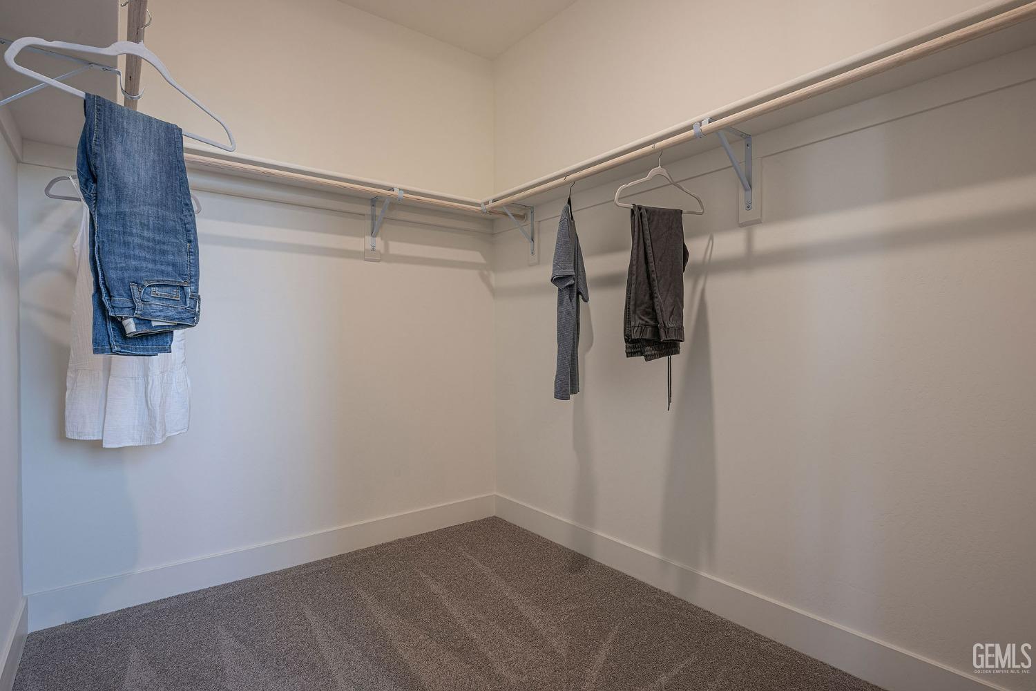 Undisclosed Address Bakersfield, CA 93311 - Photo 12 of 19 a view of walk in closet with clothes and shoes