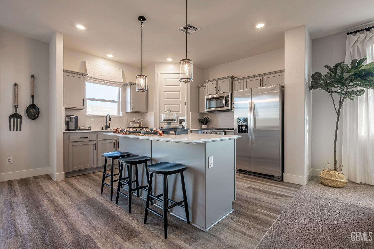 Undisclosed Address Bakersfield, CA 93311 - Photo 2 of 19 a kitchen with kitchen island a counter top space a sink appliances and cabinets