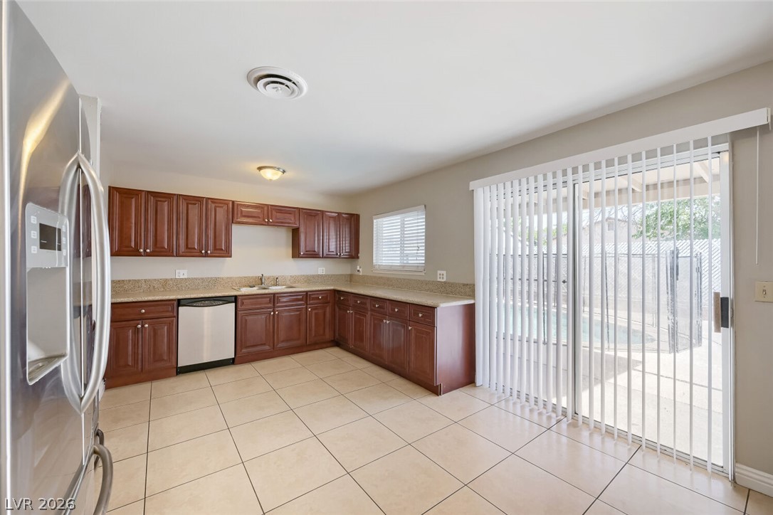 6321 Portola Road Las Vegas, NV 89108 - Photo 12 of 29 A well-lit kitchen with generous cabinetry and easy access to outdoor living.