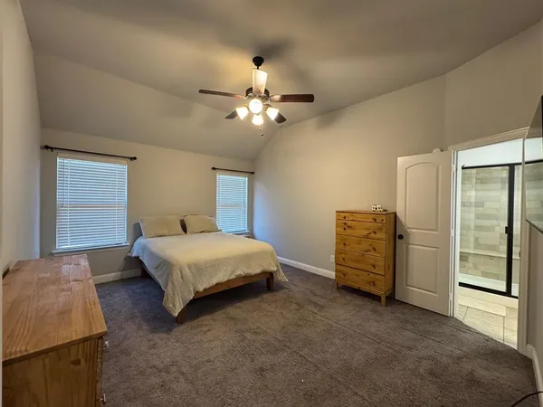 a spacious bedroom with a bed and a chandelier