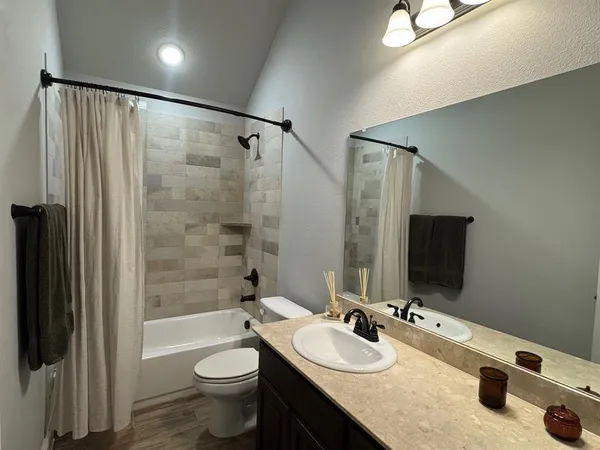 a bathroom with a double vanity sink toilet mirror and shower