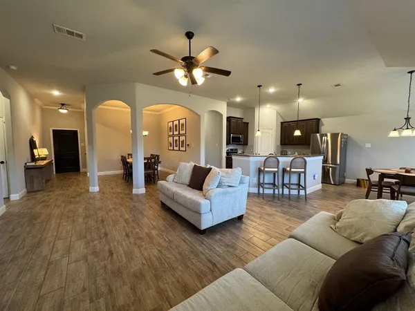 a living room with furniture and a view of kitchen