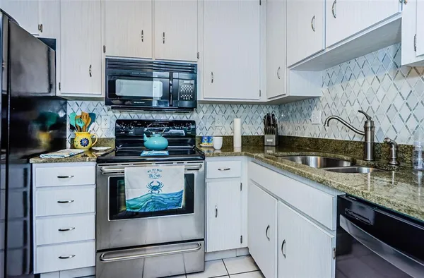 a kitchen with stainless steel appliances granite countertop a stove a microwave and cabinets
