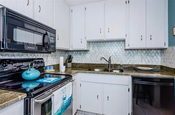a kitchen with stainless steel appliances granite countertop a sink stove and cabinets
