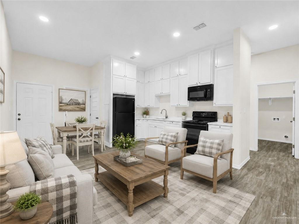 618 West 25th Street Mission, TX 78574 - Photo 2 of 8 Open-concept living space featuring wood-finish flooring, recessed lighting, and a white kitchen with black appliances