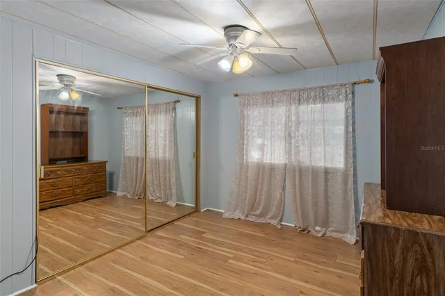 a view of a room with wooden floor and a ceiling fan