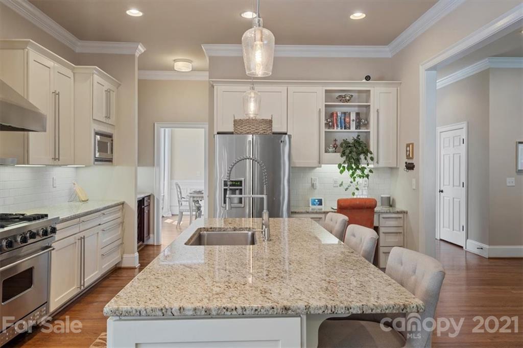 851 Stratford Run Drive Fort Mill, SC 29708 - Photo 14 of 48 a kitchen with stainless steel appliances granite countertop a refrigerator a stove top oven and a dining table with wooden floor