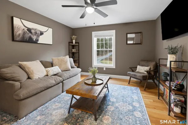 a living room with furniture a flat screen tv and a window