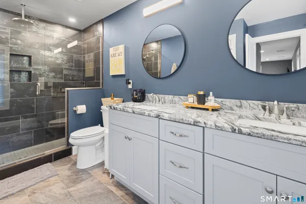 a bathroom with a toilet a sink and mirror