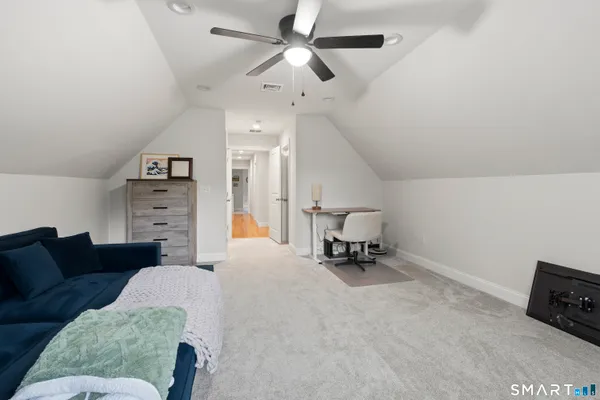 a living room with furniture and a ceiling fan