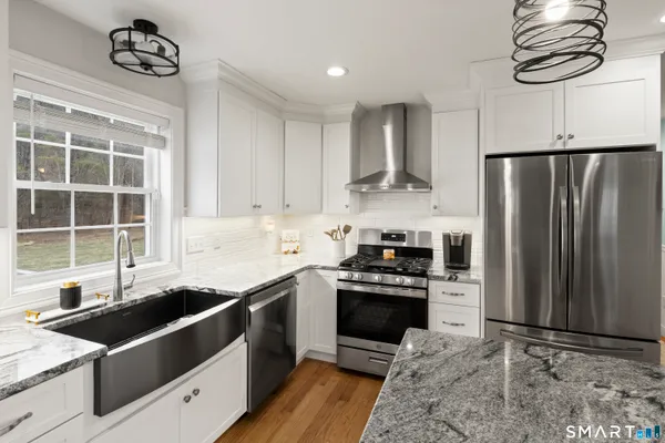 a kitchen with stainless steel appliances granite countertop a sink stove and refrigerator
