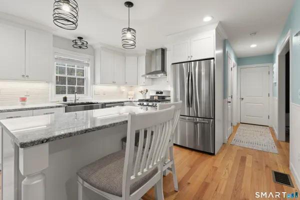 a kitchen with granite countertop a sink a counter space appliances and cabinets