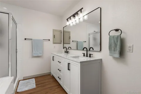 a bathroom with a double vanity sink mirror and shower