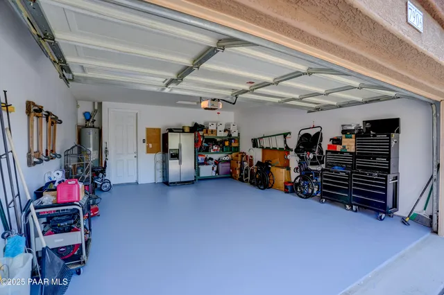 a spacious bedroom with a bed a mirror and a large window