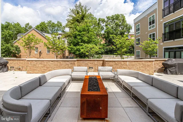 a balcony with couple of couches and potted plants