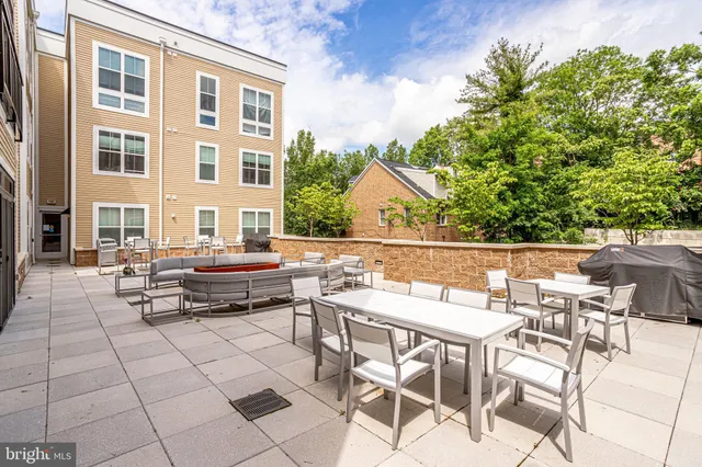 a view of a patio with a dining table and chairs with wooden floor