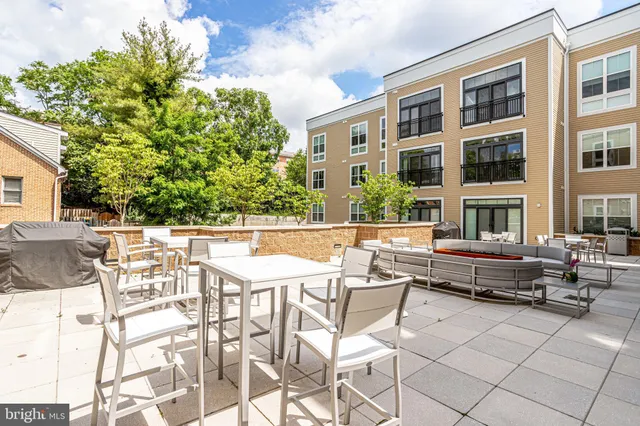 a view of a patio with couches table and chairs and potted plants
