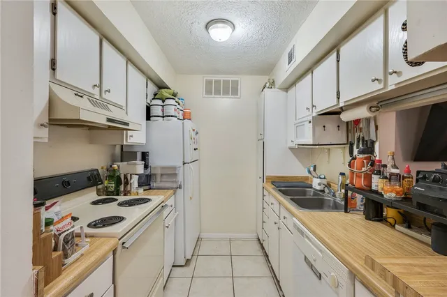 a kitchen with stainless steel appliances a stove a sink and a refrigerator