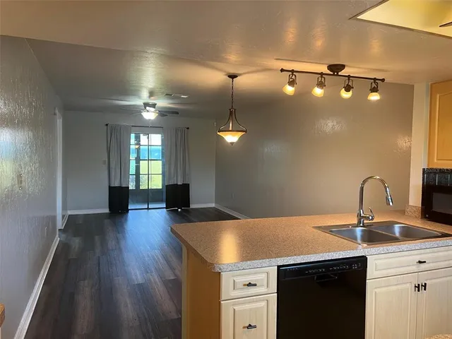 a kitchen with a sink a refrigerator and wooden floor
