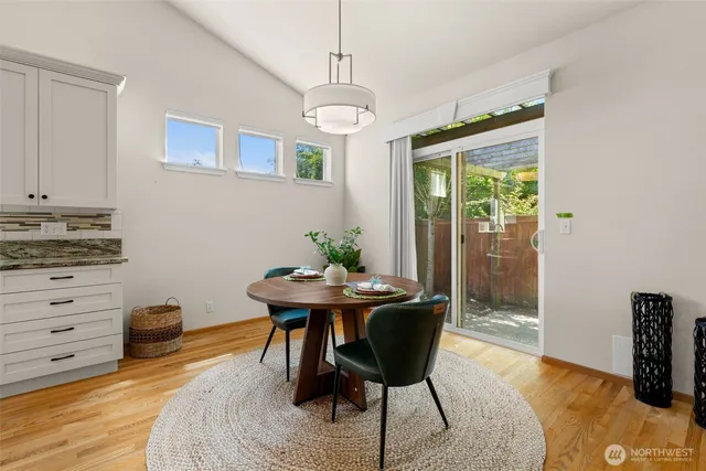 a dining room with furniture potted plants and wooden floor
