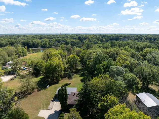 an aerial view of lake residential house with outdoor space and trees all around