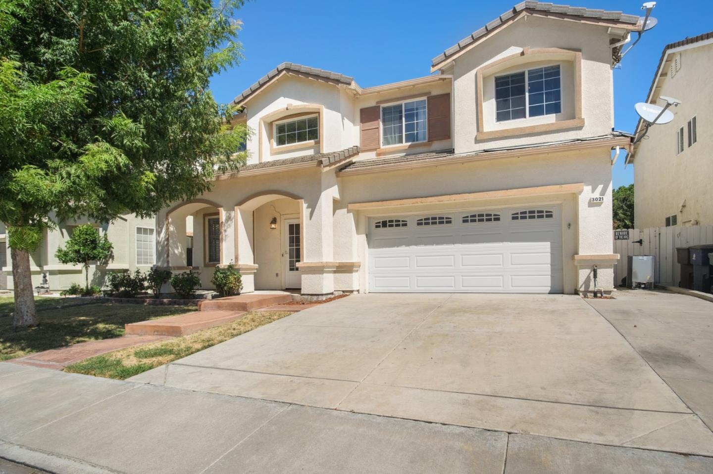 a front view of a house with yard and parking