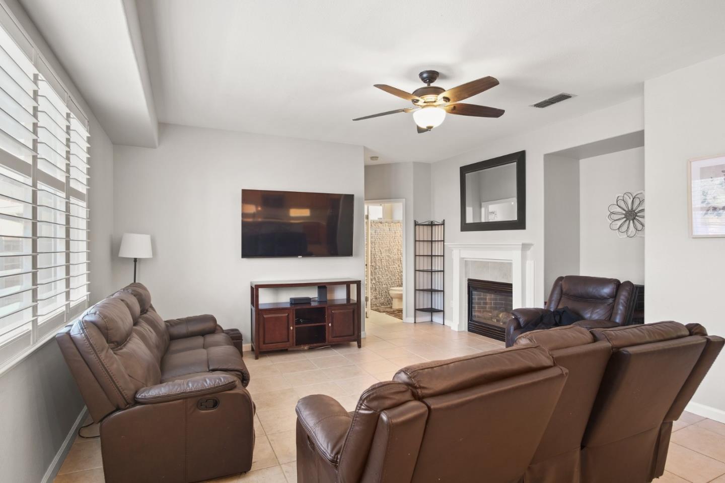3021 Simms Lane Tracy, CA 95377 - Photo 18 of 33 a living room with furniture a fireplace and a flat screen tv