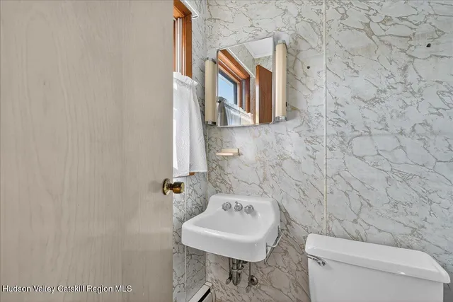 a bathroom with a toilet a sink and mirror