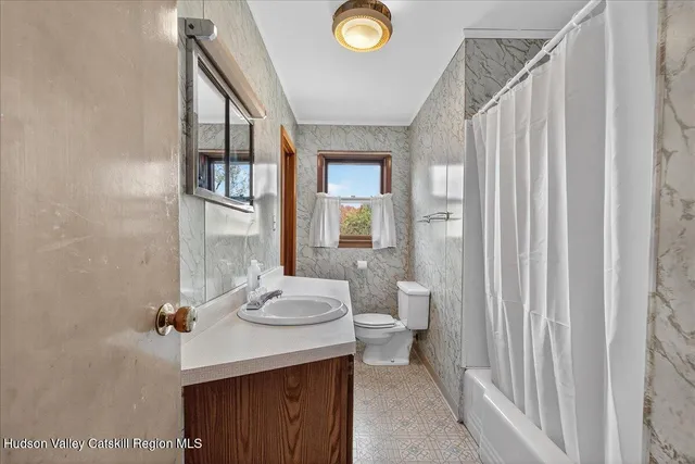 a bathroom with a sink a toilet and shower curtain