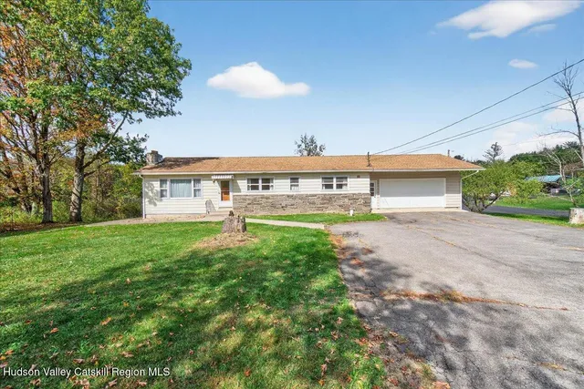 a view of a house with a yard and a garage