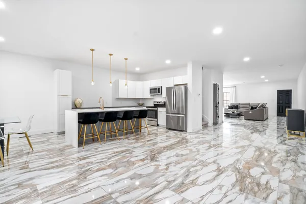 a kitchen with stainless steel appliances kitchen island granite countertop a refrigerator and a stove top oven