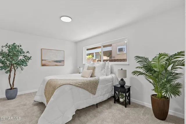 a bedroom with a bed and a potted plant