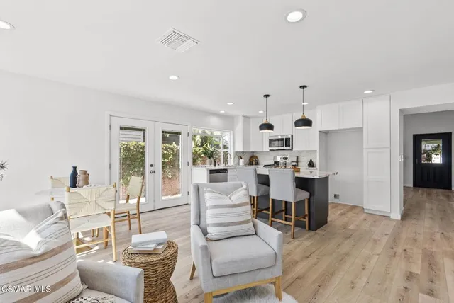a kitchen with sink a stove and chairs