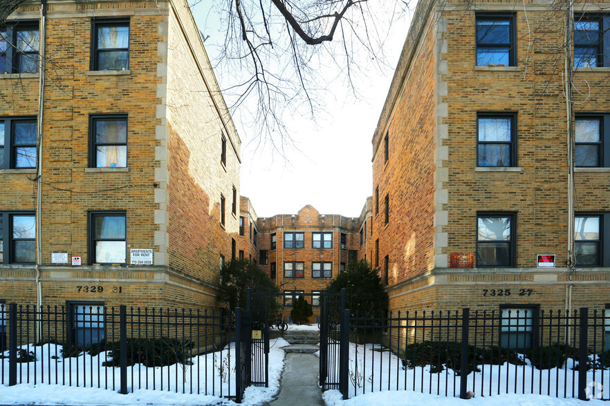 7325 North Honore Street, Unit 3B Chicago, IL 60626 - Photo 1 of 10 a view of a brick house with large windows and a small yard