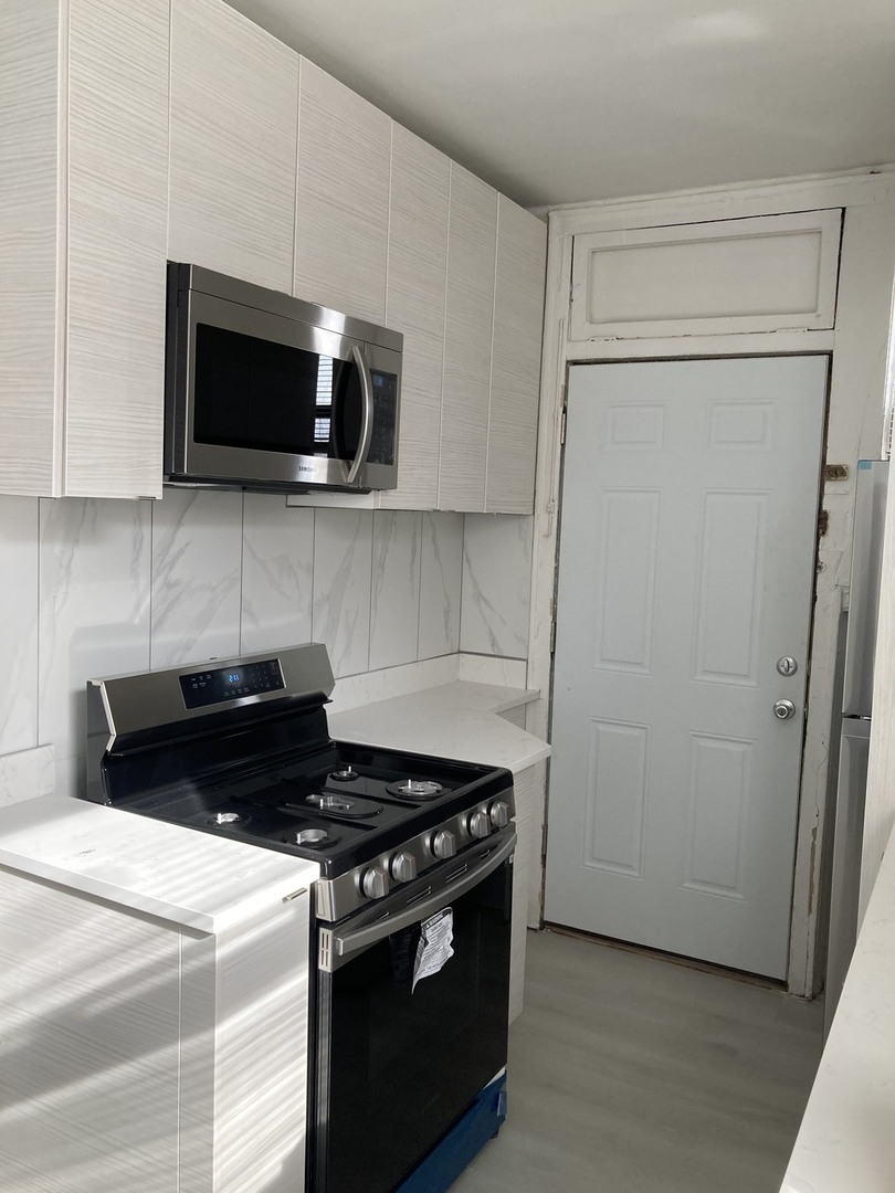 7325 North Honore Street, Unit 3B Chicago, IL 60626 - Photo 6 of 10 a kitchen with a stove and a microwave