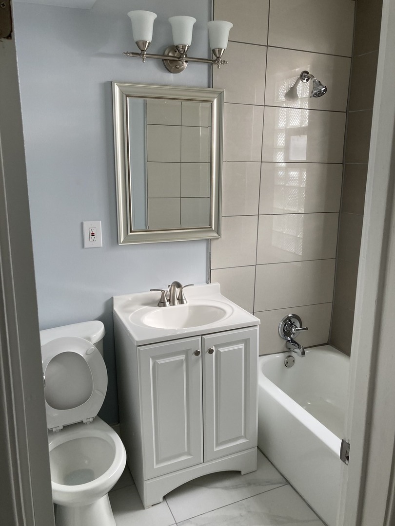 7325 North Honore Street, Unit 3B Chicago, IL 60626 - Photo 10 of 10 a bathroom with a toilet sink and mirror